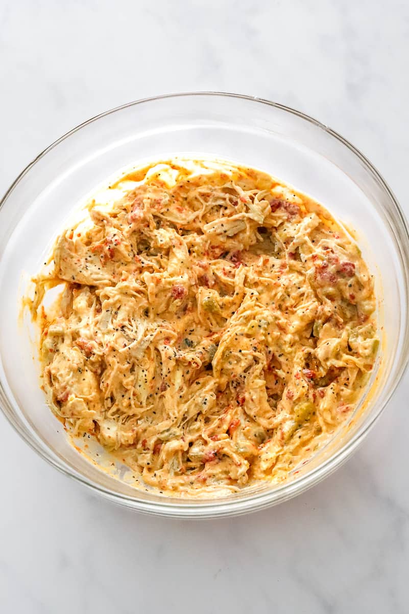 Glass bowl filled with shredded creamy chicken.
