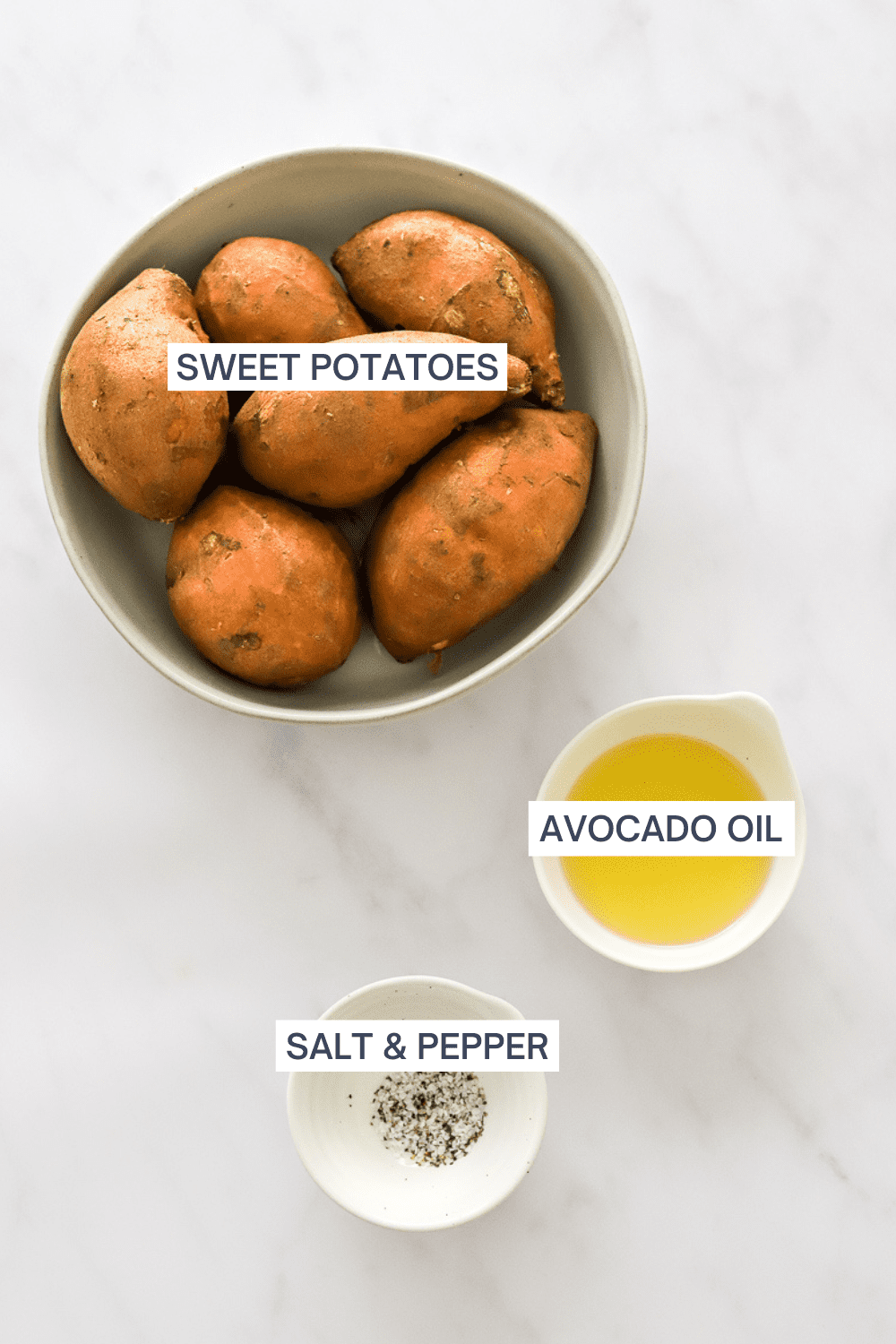 Bowl of sweet potatoes, with a bowl of oil and bowl of salt and pepper in front of it with labels over each ingredient. 