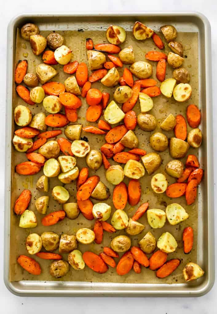 Roasted potato and carrots on a baking sheet. 