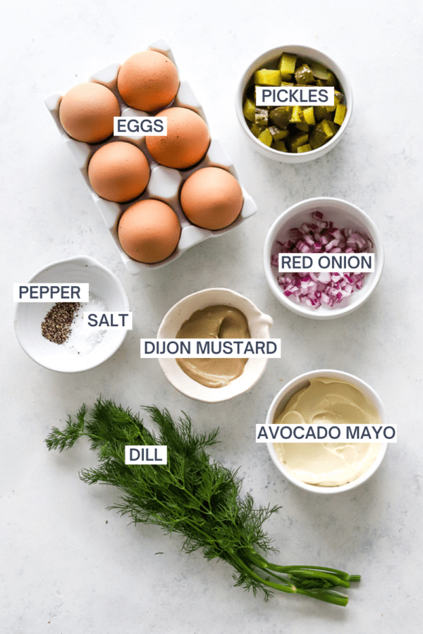 Ingredients for healthy egg salad with labels over each ingredient.