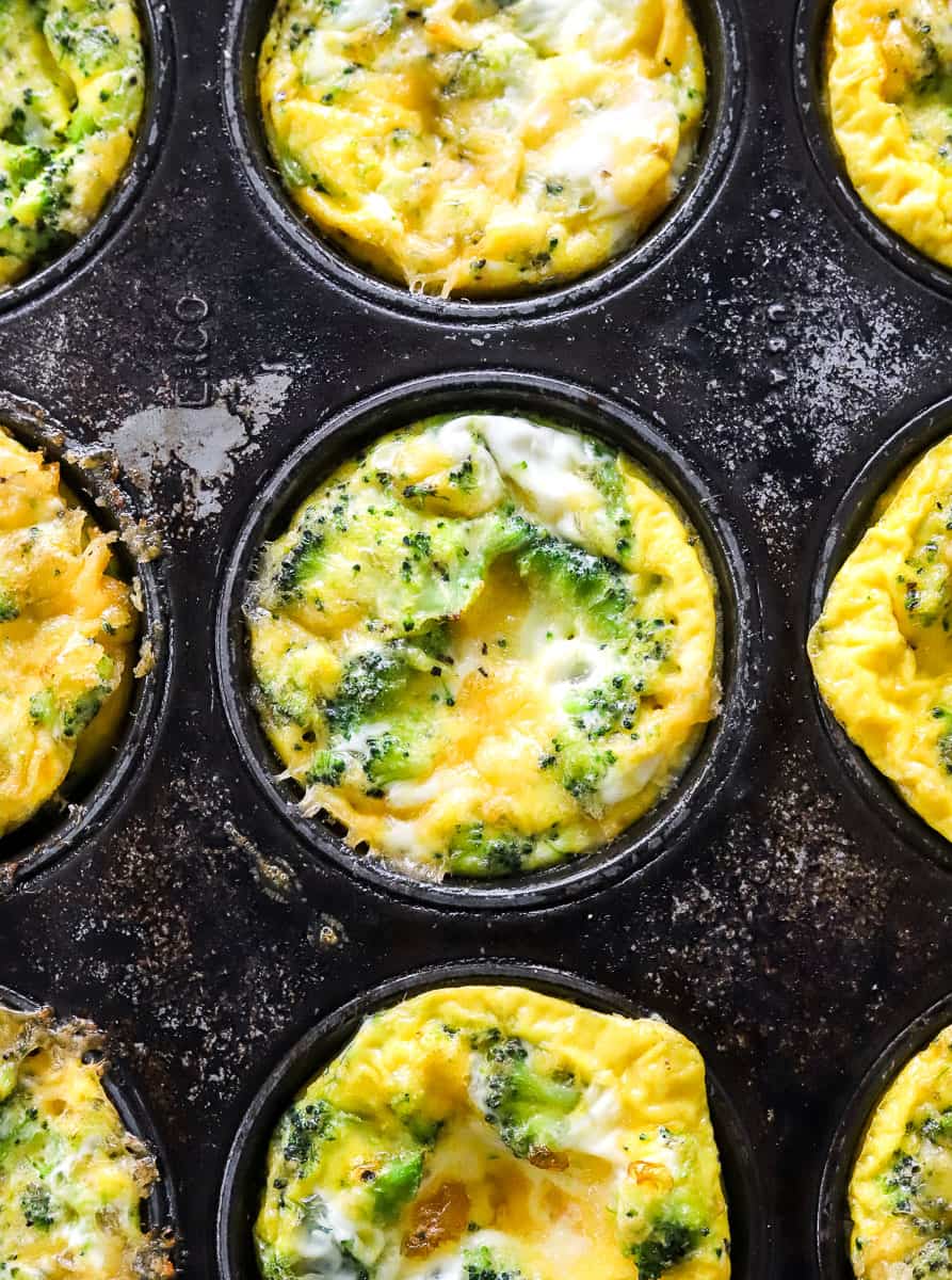 Baked broccoli and cheddar mini quiche in a muffin pan.