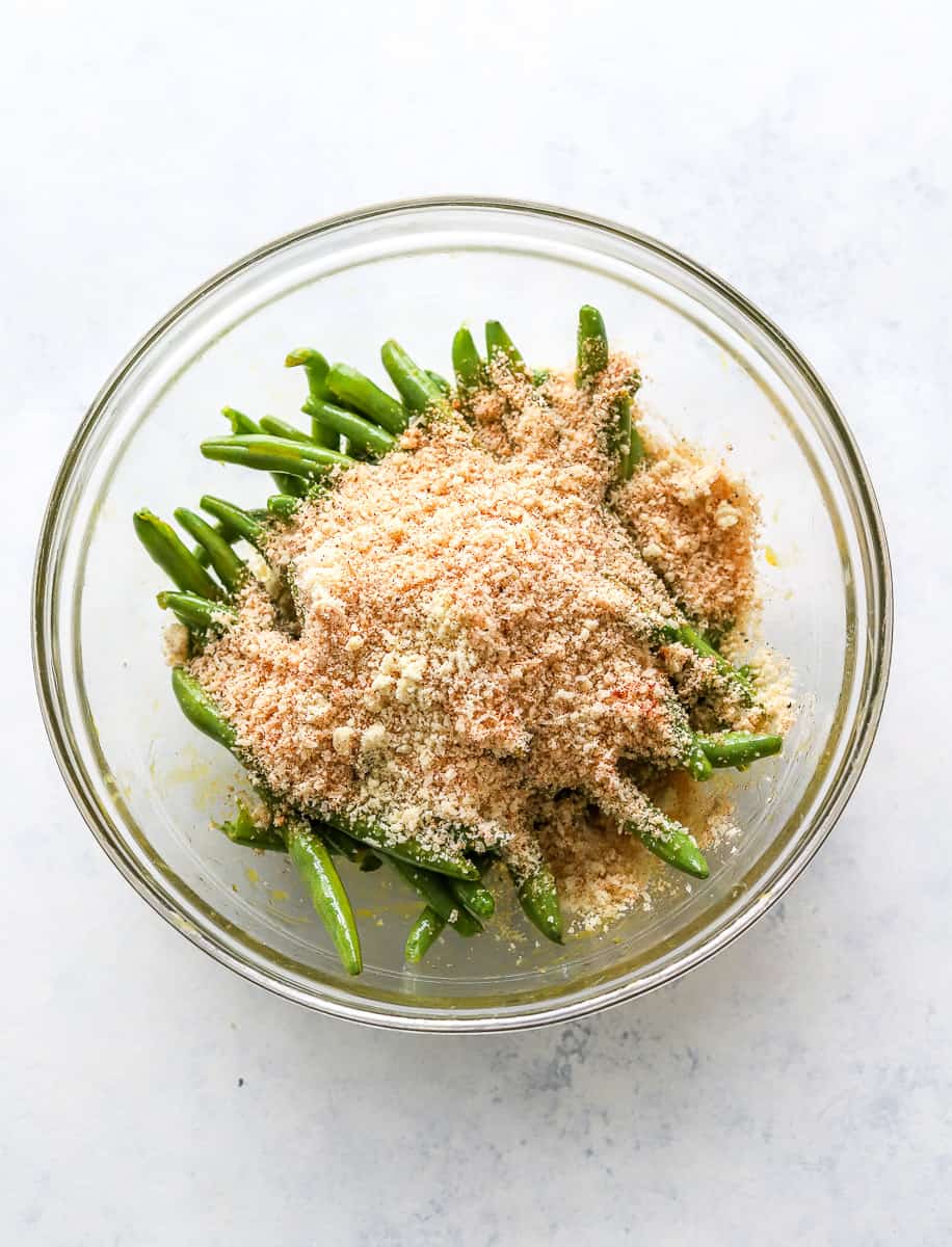 Bowl of green beans with almond flour breading on to pot them.