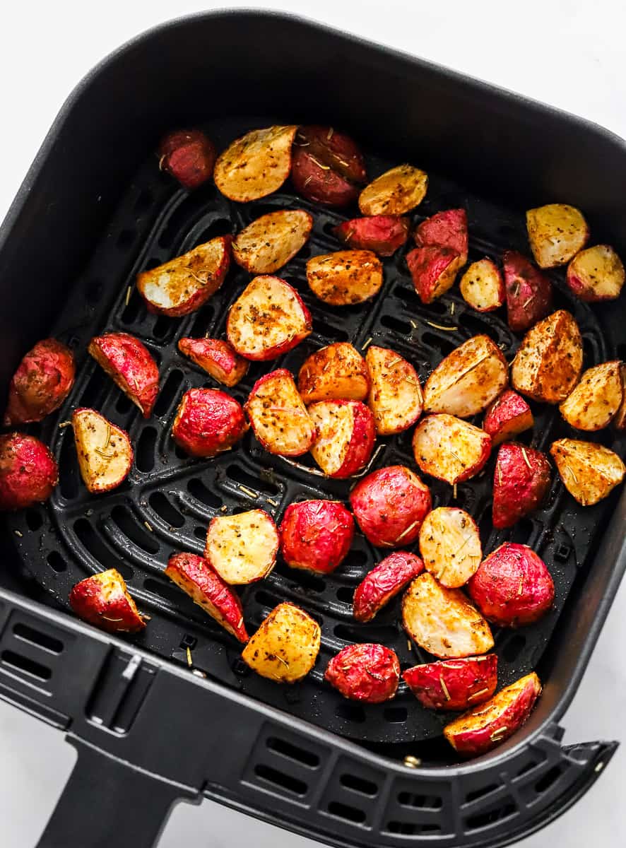 Cooked, roasted radishes in a black air fryer basket. 