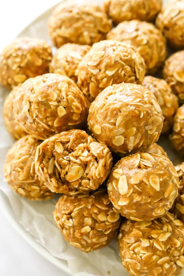 Close up of a oatmeal and nut butter ball with a bite taken out of it with more balls around it.
