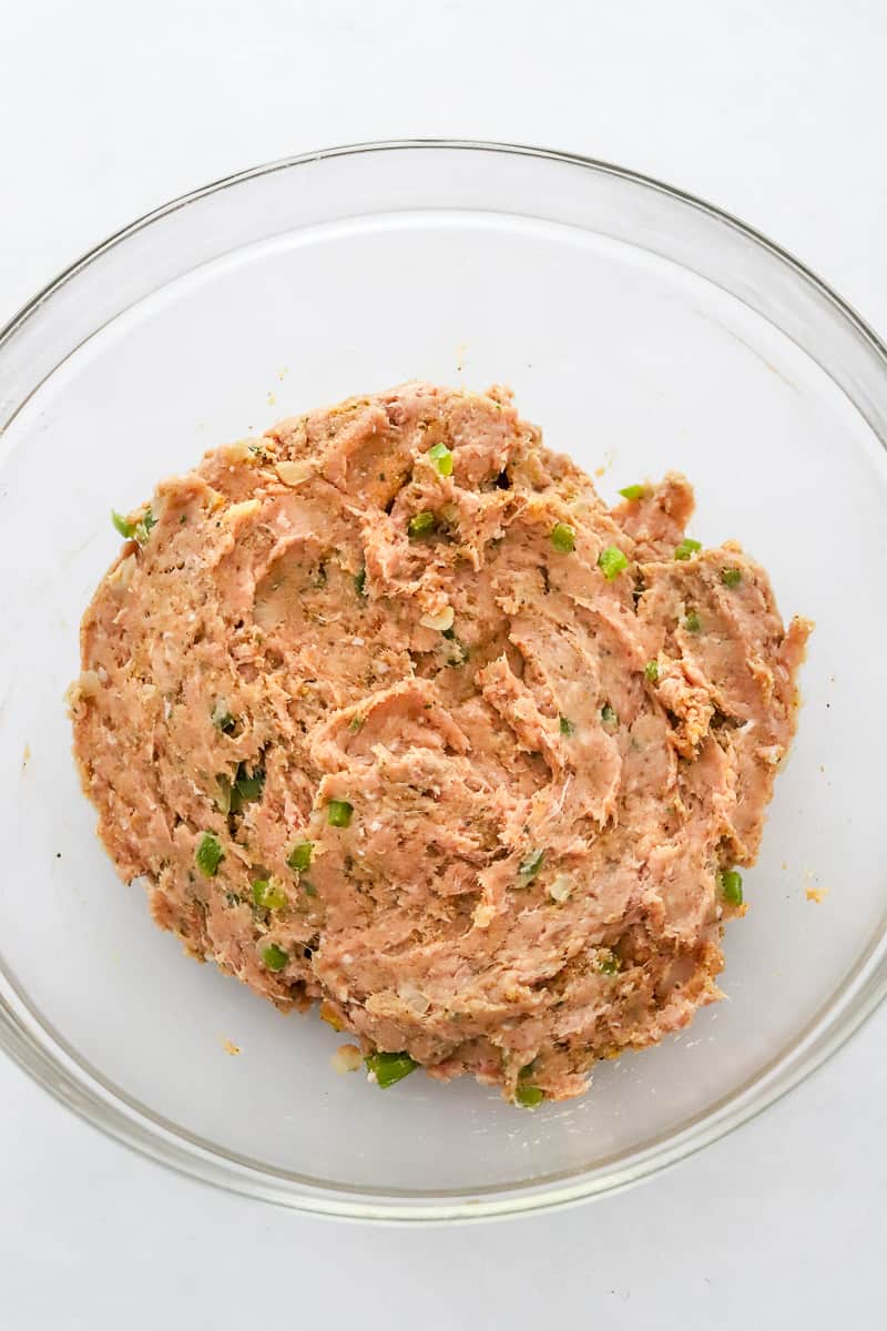 Raw mixed ground turkey mixture in a glass mixing bowl.