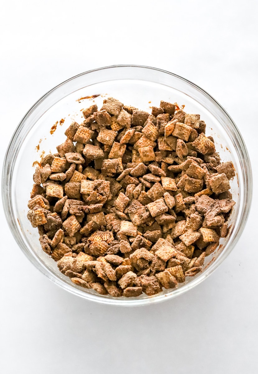 Chocolate coated Chex mix cereal in a round glass bowl.