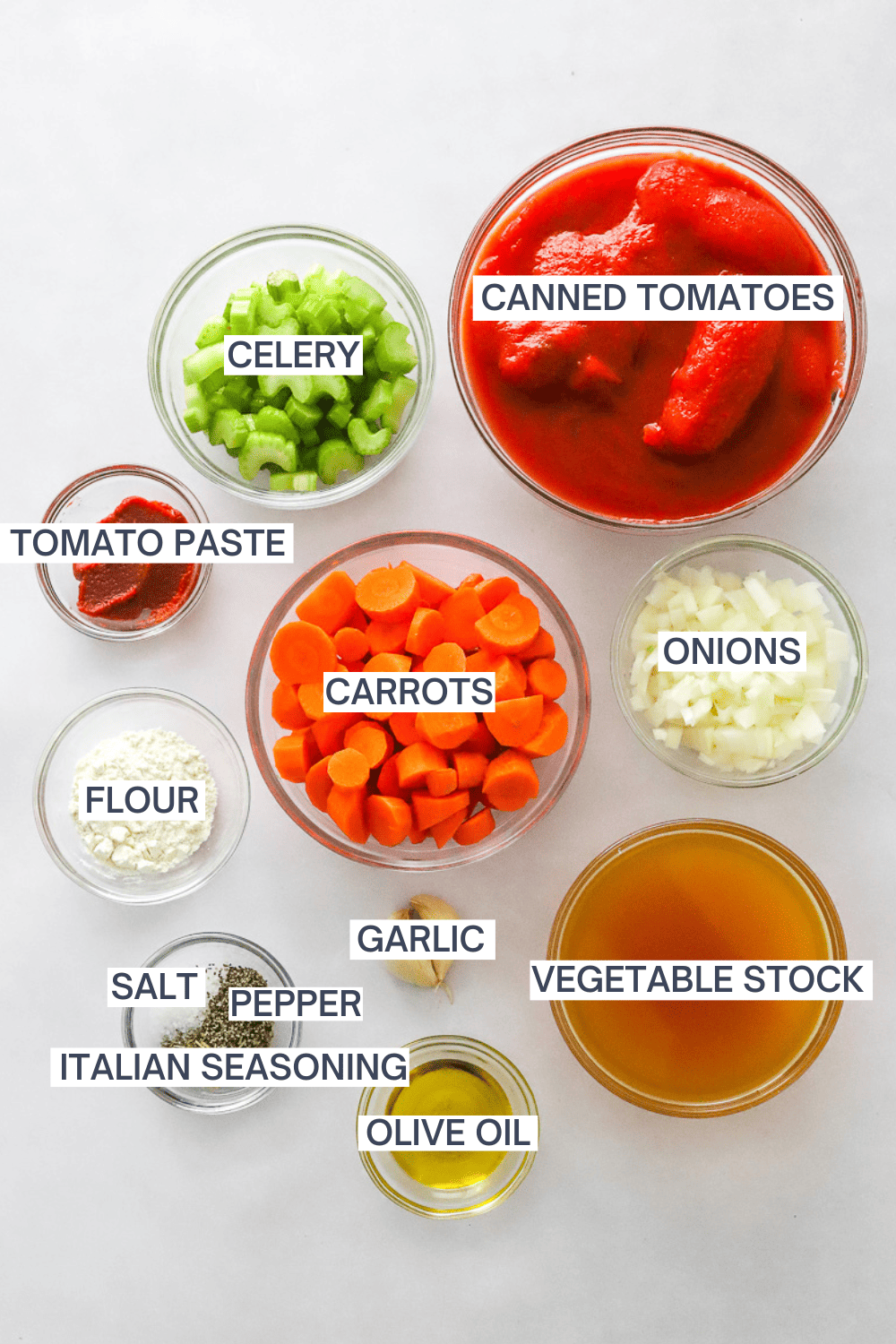 Ingredient for homemade vegan tomato soup with labels over each ingredient. 