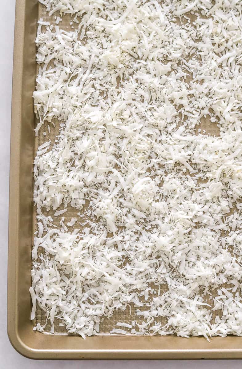 Shredded coconut on a baking sheet.