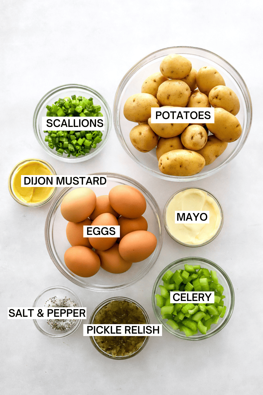 Ingredients for potato salad with labels over each ingredient.