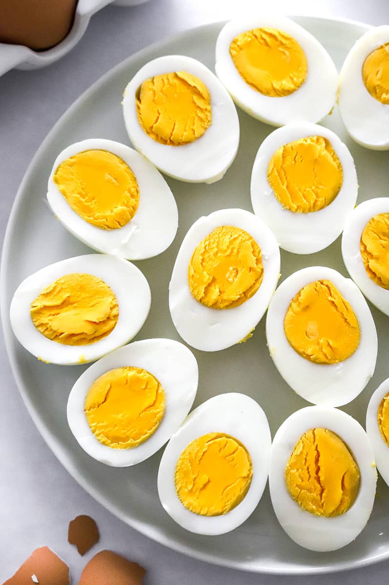 rd boiled eggs cut in half on a round white plate.
