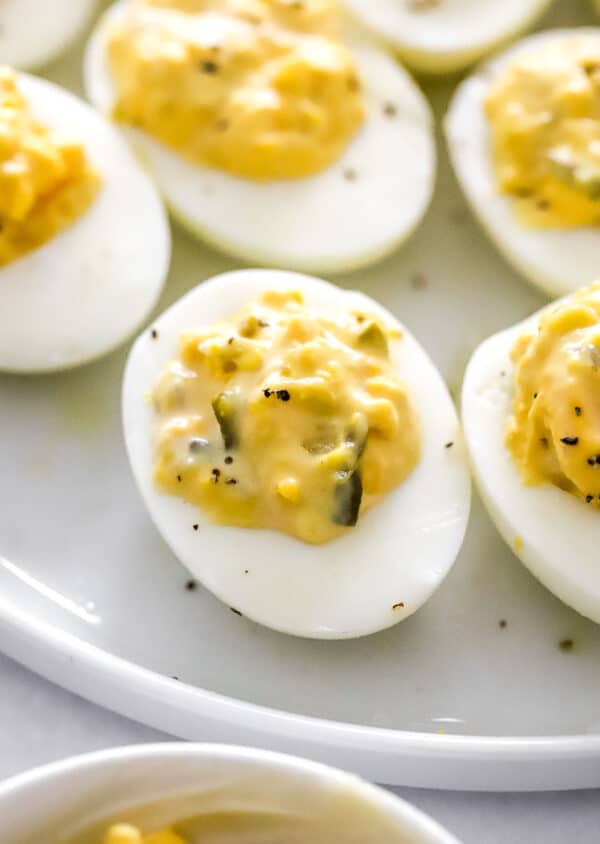 Cooked eggs filled with deviled egg filling on a plate.