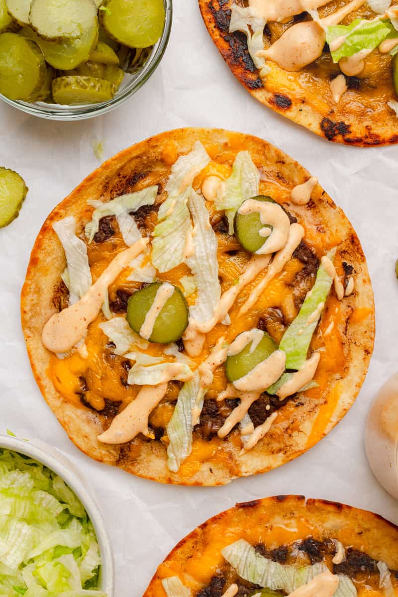 Smash burger taco topped with pickles, lettuce and burger sauce. 