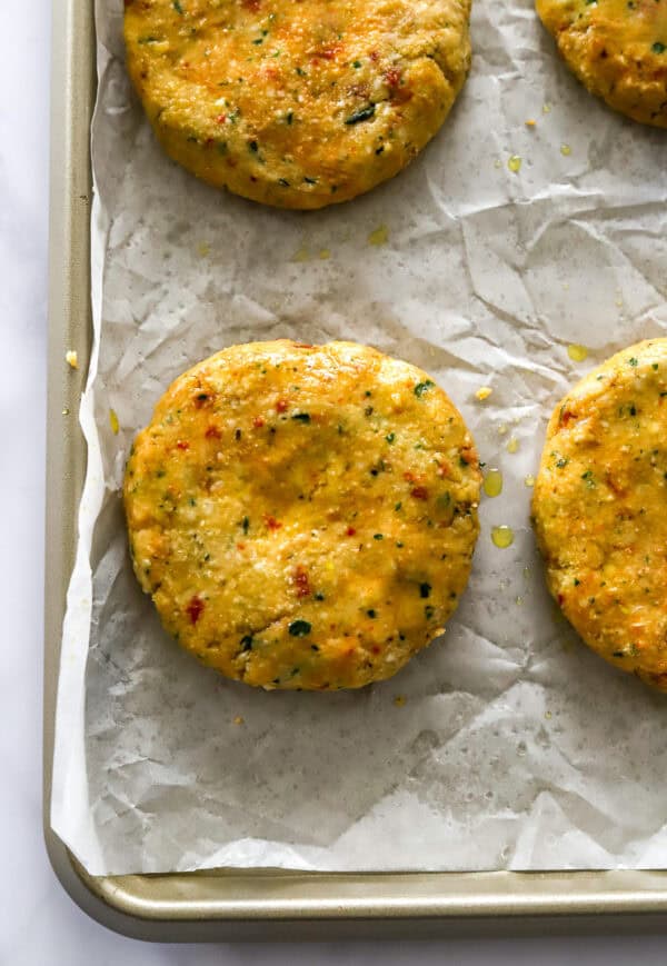 Formed veggie burger patties on a lined baking pan.