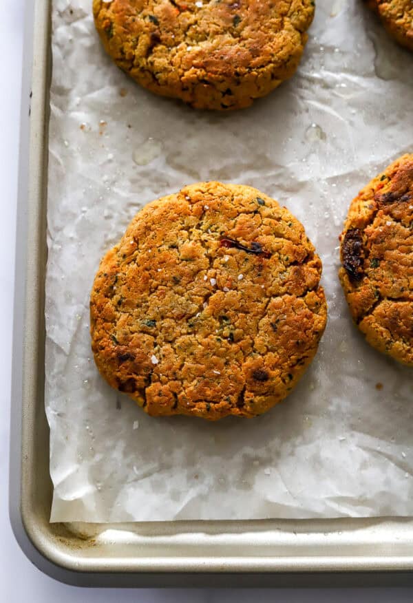 Formed and baked chickpea burger patties on a lined baking sheet.
