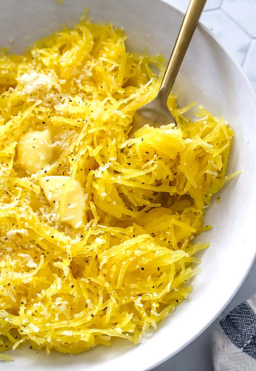 Yellow squash in a bowl with a fork in the bowl.