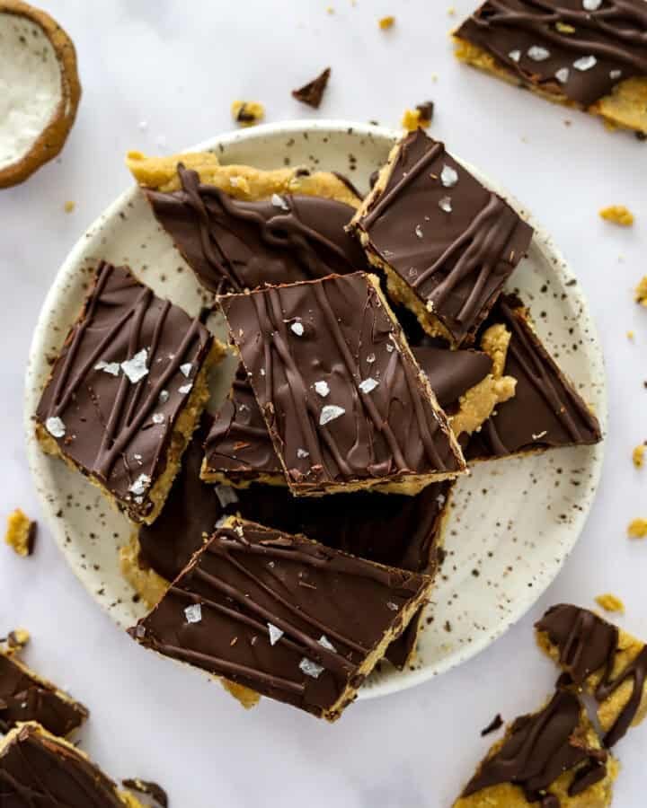 Plate of large pieces of cookie dough bark on a plate with more bark around it.