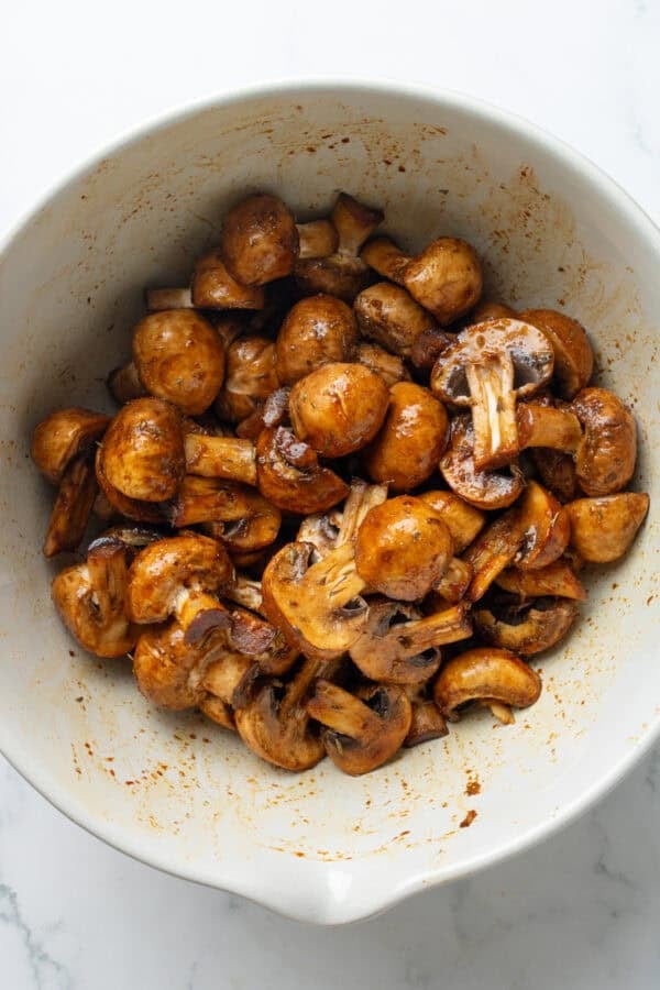 Chopped seasoned mushrooms in a white mixing bowl.