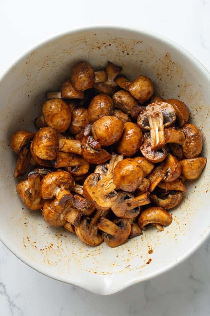 Chopped seasoned mushrooms in a white mixing bowl.