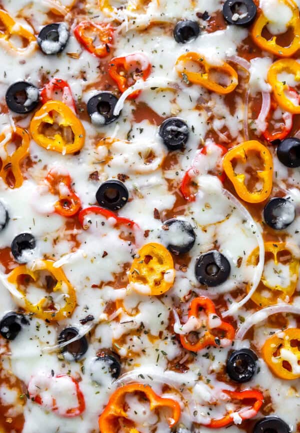 Close up of cheesy veggies on pizza.