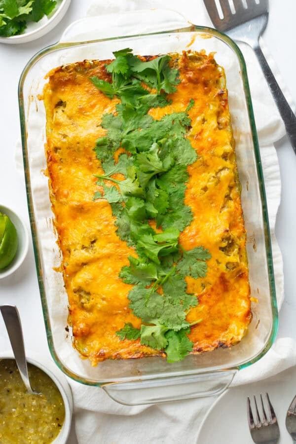 Pan cooked cheese green chicken enchiladas topped with chopped cilantro.