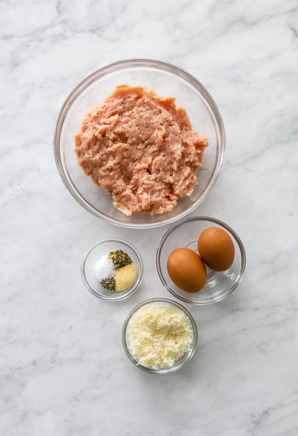 Ingredients for chicken crust pizza in glass bowls.