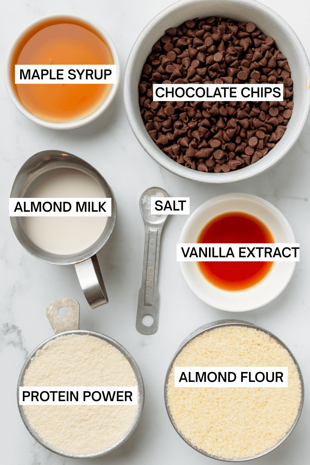 Ingredients for protein cookie dough balls in bowls with labels over each ingredient. 