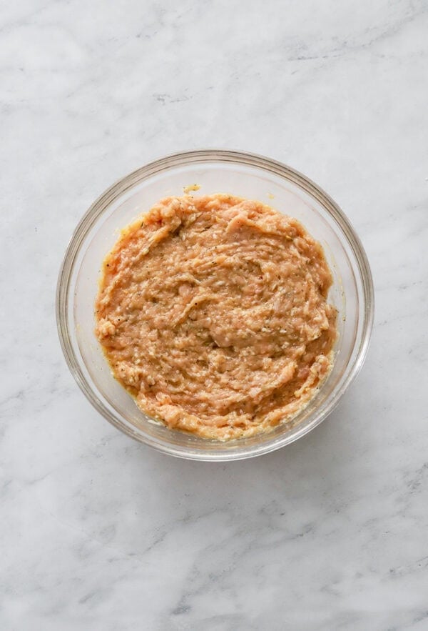 Mixed chicken pizza mixture in a glass bowl.