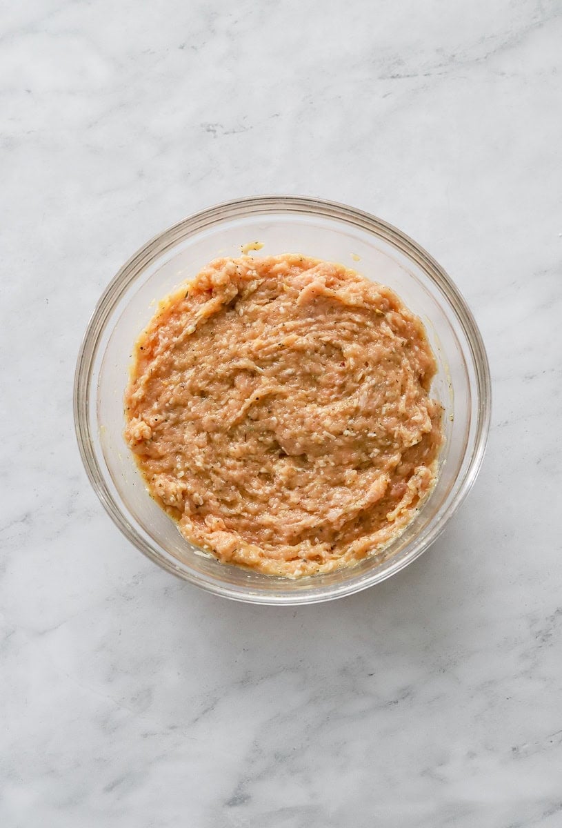 Mixed chicken pizza mixture in a glass bowl.