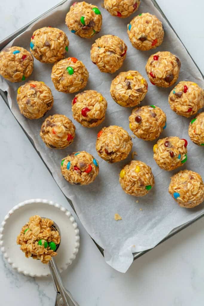 Line pan filled with no bake energy bites with a scoop on a plate next to it. 
