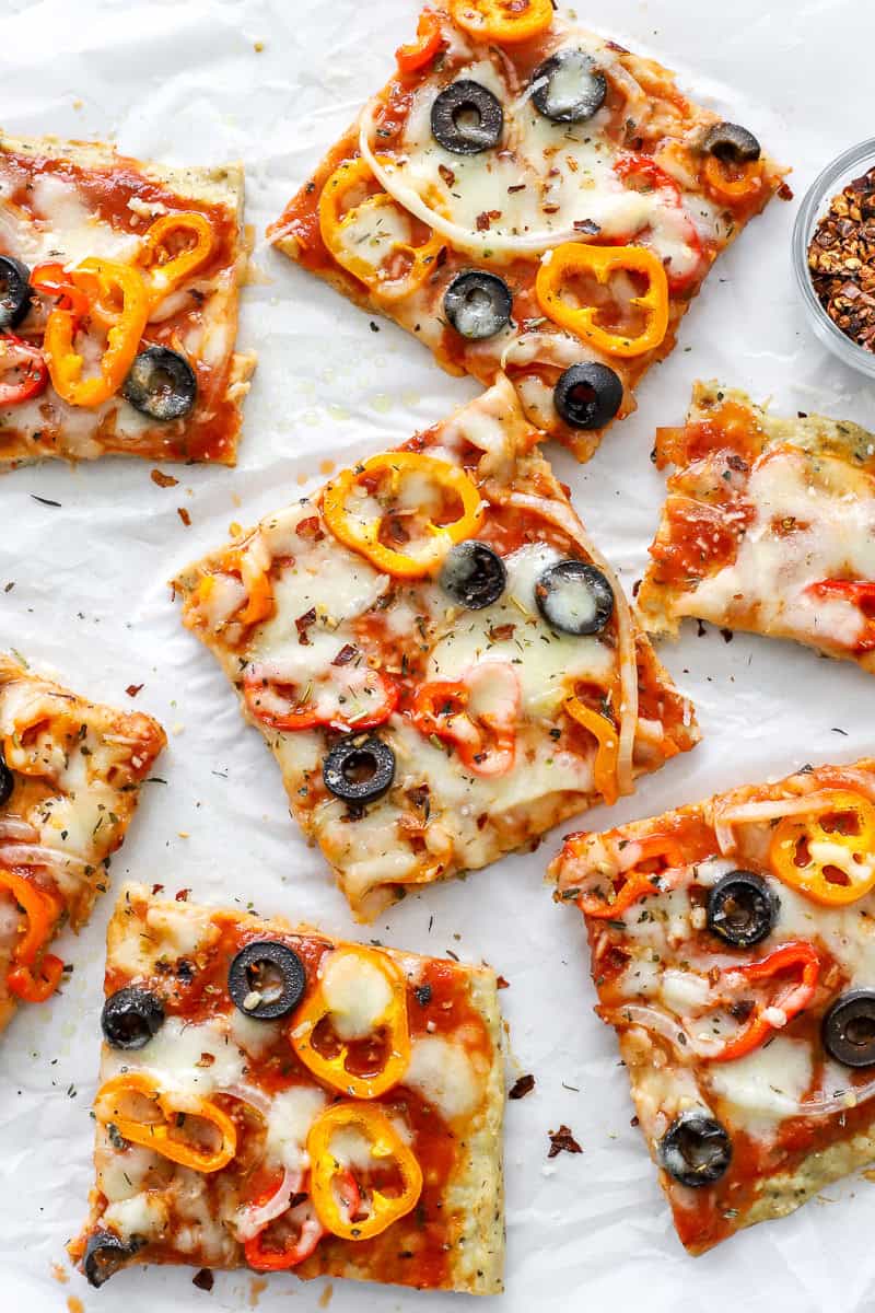 Cut squares of low carb chicken pizza topped with melty cheese and veggies. 
