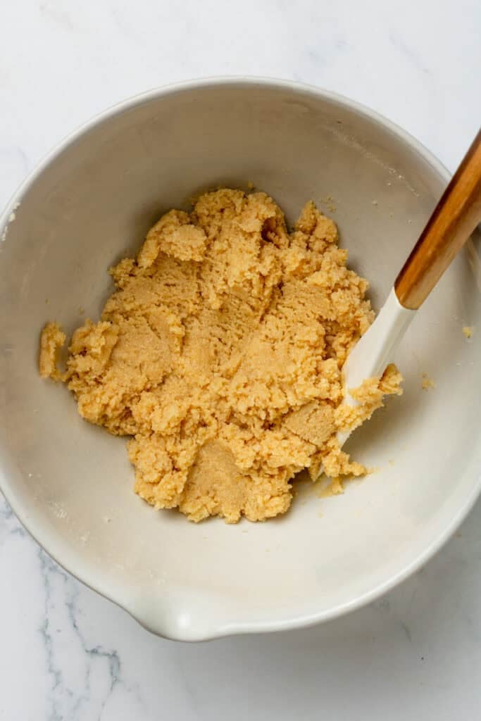 Mixed edible protein cookie dough before adding chocolate chips in a mixing bowl. 