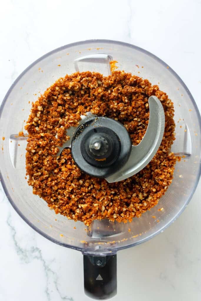Cookie crust ingredients blended in the bowl of a food processor. 
