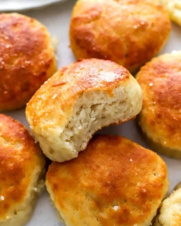 Cooked Greek yogurt biscuits with a bite taken out of one.