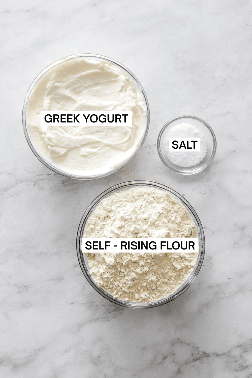 Ingredients for Greek yogurt biscuits in bowls with labels over each ingredient.