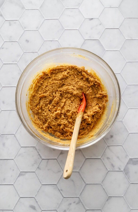 Peanut butte filling in glass bowl with small mixing spoon in the bowl.