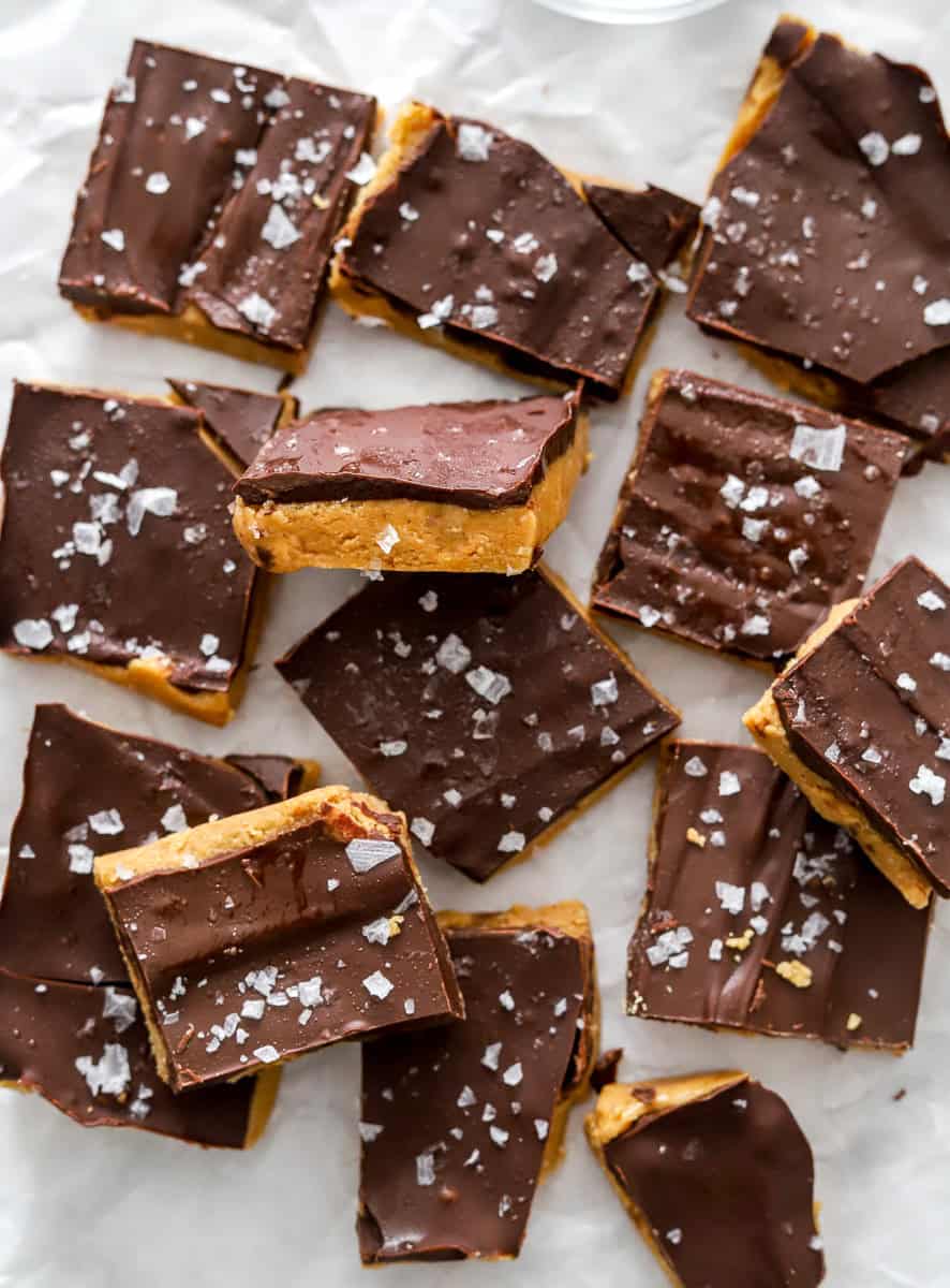 Cut square peanut butter bars on white parchment paper