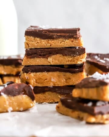 Stack of homemade peanut butter bars with more around it.