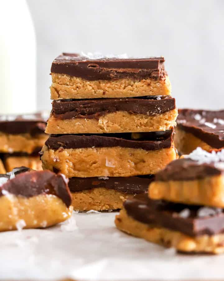 Stack of homemade peanut butter bars with more around it.