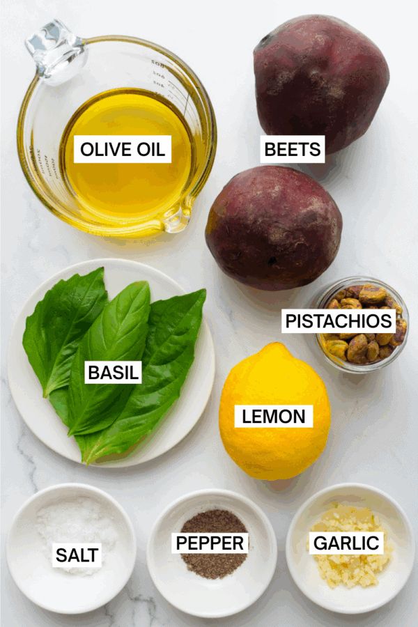Ingredients for beet pesto in bowls with labels over each ingredient.