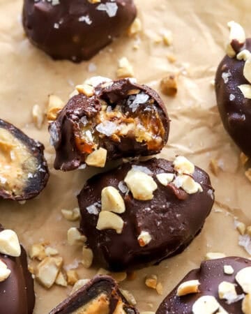 Date snickers on brown paper with a bite taken out of one of them.