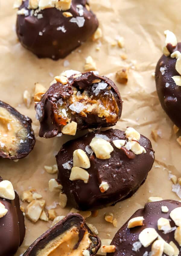 Date snickers on brown paper with a bite taken out of one of them.