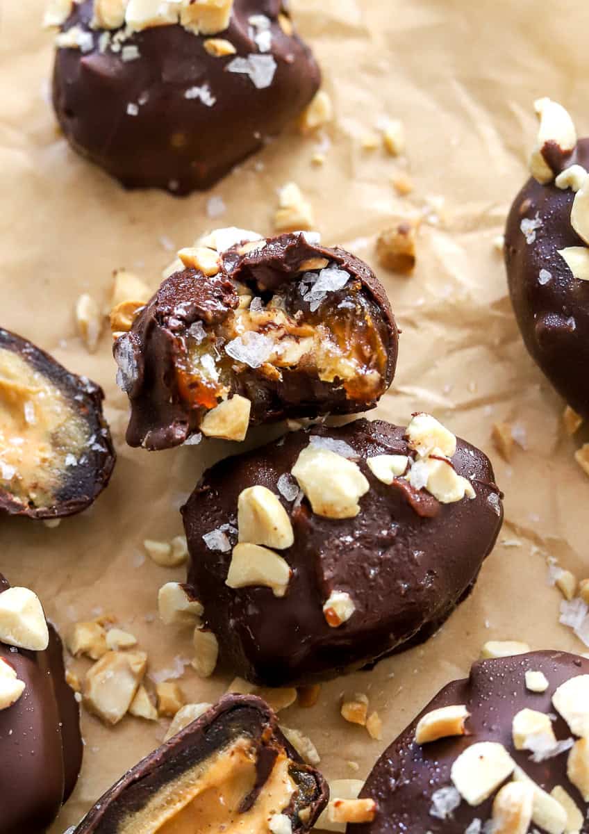 Date snickers on brown paper with a bite taken out of one of them. 