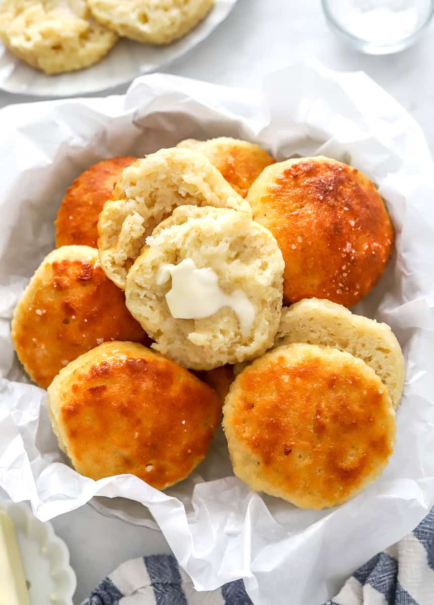 Pile of yogurt biscuits with butter on one of them.