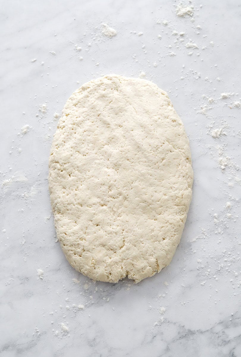 Rolled out biscuit dough rolled out on a flat surface.