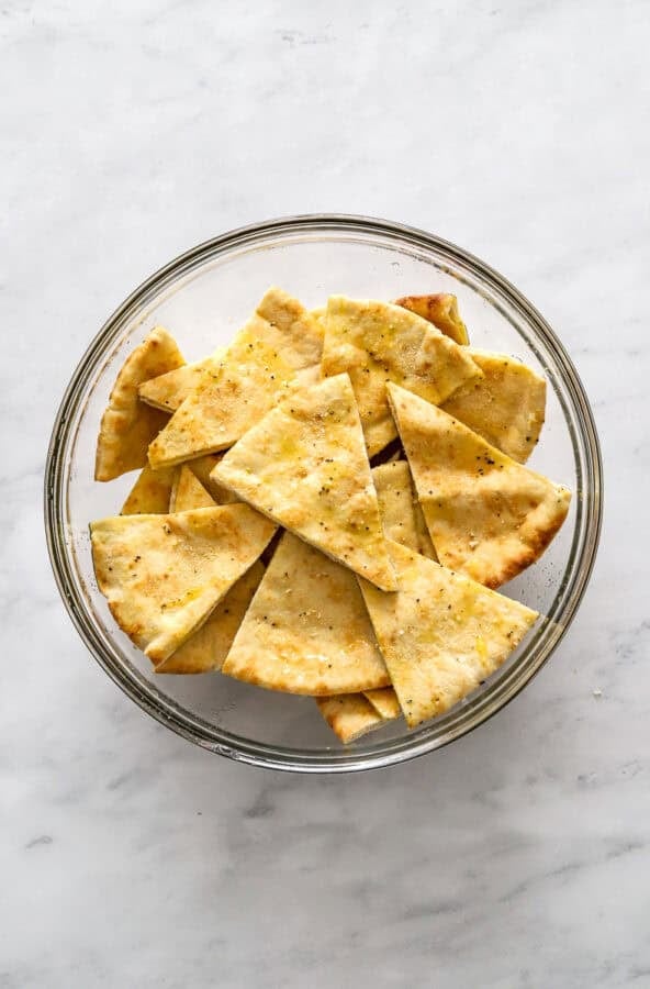 Seasoned pita wedges in a glass bowl.