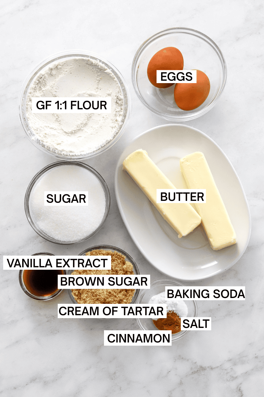 Ingredients for snickerdoodle cookies in bowls with labels over each ingredient.