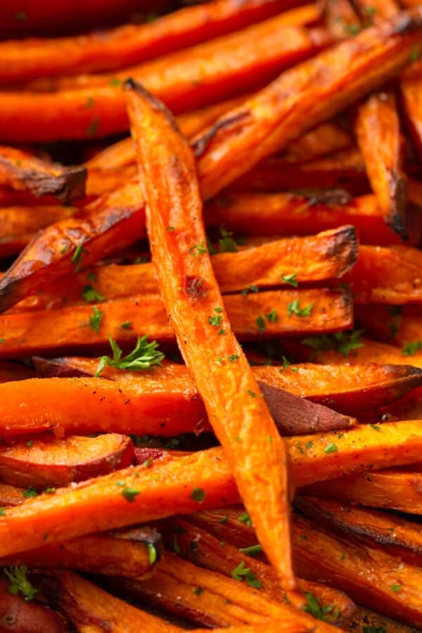Golden baked fries made from sweet potato on a baking pan.