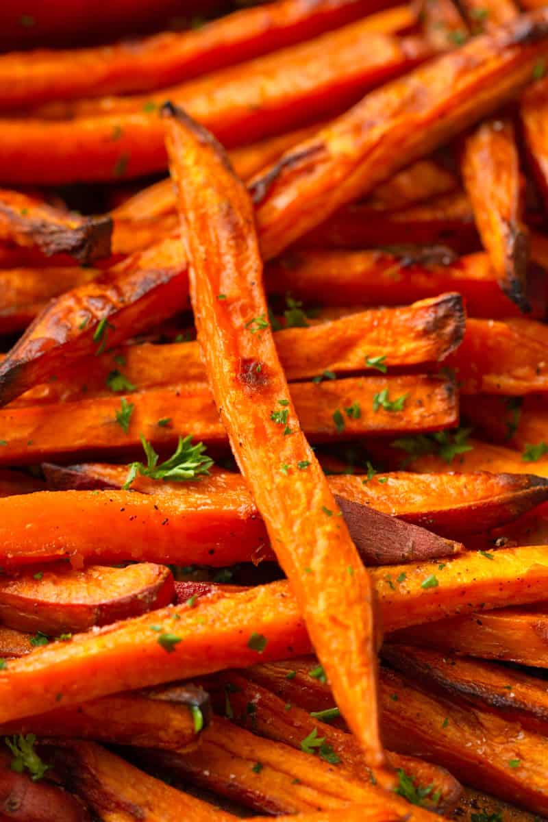 Golden baked fries made from sweet potato on a baking pan. 