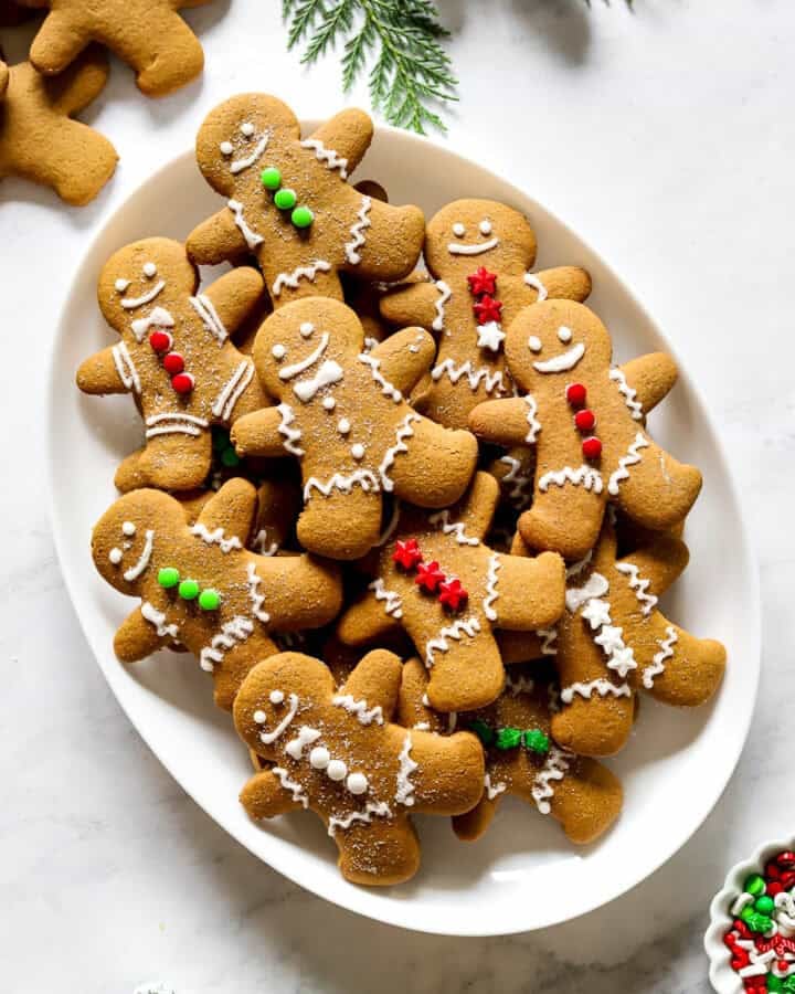 Platter filled with gluten free gingerbread cookies that are decorated like gingerbread men.