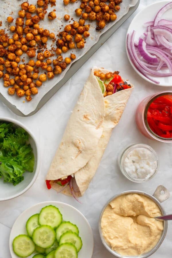 Hummus flour wrap with filling ingredients around it.